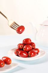 Seedless red dates in a white plate, indoor shot, clean background, closeup