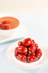 Seedless red dates in a white plate, indoor shot, clean background, closeup