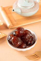 Seedless red dates in a white plate, indoor shot, clean background, closeup