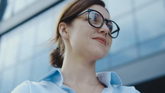 Smiling self-confident woman standing near office building starting own business