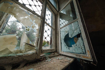 Low angle of dirty broken old fashioned window with shabby windowsill of damaged building