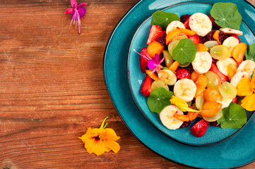 Fruit salad with nasturtium, copy space.