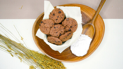 Chocolate chip cookies in a wicker basket on a wooden table