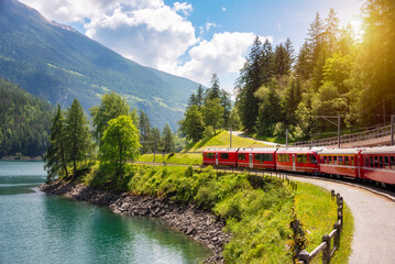Train going along lake in Switzerland in summer