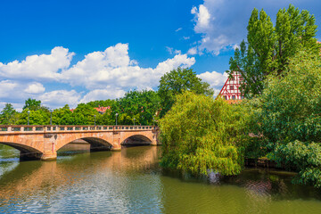 Fototapeta na wymiar Nuremberg's cityscape features River Pegnitz and Maxbrücke, the oldest stone bridge in the city.