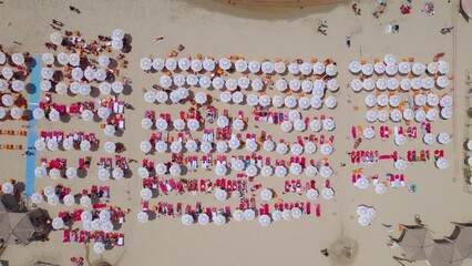 The large amount of colorful beach umbrellas of the Tel Aviv beaches with red sunbeds and orange plastic chairs on an ordinary summer day - abstract top down view - Powered by Adobe