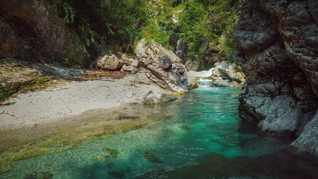 Mountain river Soča in Triglav National park Slovenia, Slovenian alps. Clear blue water is rushing through a naturally formed canyon with waterfall cascade and rocks. Cinemagraph seamless video loop.