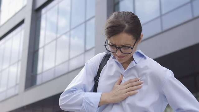 Anxious woman rubbing sore chest feeling pain, risk of heart attack, tachycardia