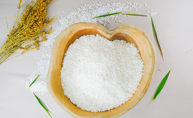 Top view of Paddy rice and white rice in wooden bowl on white background
