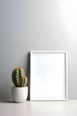 A white sheet of paper, a blank sheet in a frame, next to a cactus in a pot.