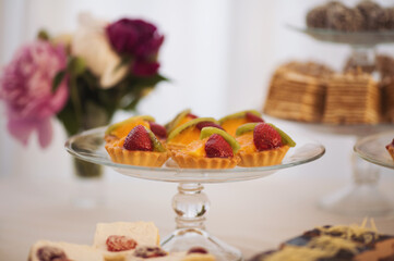 Closeup view photography of many small souffle cakes served on plate on table for cocktail party or on shelves of store. Christmas, birthday or wedding holiday dinner. catering food.  tasty dessert.