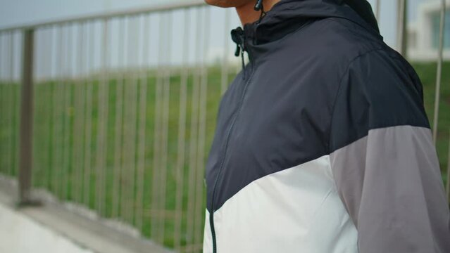 Hand zipping sport jacket on street closeup. Fitness man training in morning