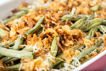 A traditional green bean casserole topped with French Fried Onions and cream of mushroom