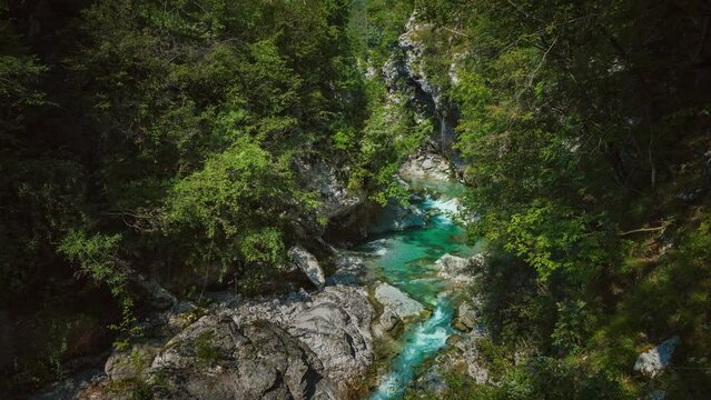 Soča mountain river in Triglav National park Slovenia, Slovenian alps. Clear blue water is rushing through a naturally formed canyon with waterfall cascade and rocks. Cinemagraph seamless video loop.