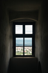 Old vintage castle window with view of mountains town, Palanok Castle in Mukachevo town, Ukraine.