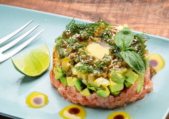 Salmon tartare dish on blue plate close up.