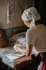 Obraz premium A woman in traditional Ukrainian clothing kneads bread dough.