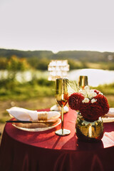 Festive table on the lawn in the middle of the forest. Romantic, festive atmosphere during a marriage proposal.