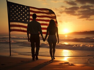 The American flag billows behind a silhouette of a couple at sunset on a beach