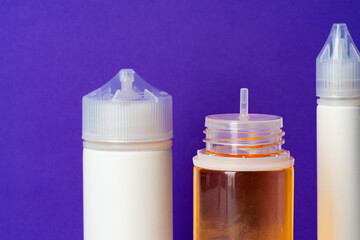 Electronic cigarettes liquid bottles on purple background