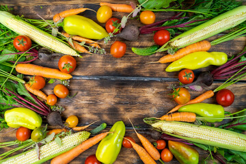 fresh vegetables from the garden beds carrots and beets, tomatoes and cucumbers on an old wooden background