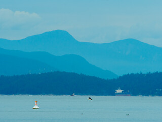 English bay in Vancouver during a cloudy day with the ocean and mountains as a view
