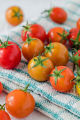 Yellow and red cherry tomatoes close up on a checkered textile.