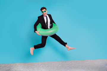 Fototapeta na wymiar Full length photo of excited funky man wear black suit jumping hurrying journey empty space isolated blue color background