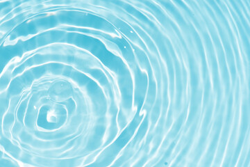 Blue water with ripples on the surface. Defocus blurred transparent blue colored clear calm water surface texture with splashes and bubbles. Water waves with shining pattern texture background.