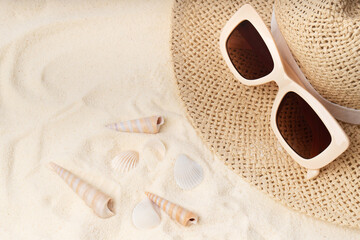 Obraz premium Modern trendy neutral beige sunglasses with orange brown glasses on straw rattan hat.