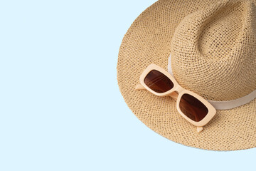 Modern trendy neutral beige sunglasses with orange brown glasses on straw rattan hat.