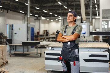 Portrait of young male carpenter standing in the wood workshop