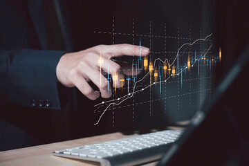 investment and finance concept, businessman holding virtual trading graph and blurred light on...
