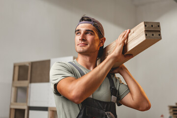 Portrait of young male carpenter standing in the wood workshop