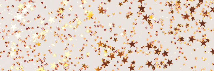 Banner with glowing golden stars and crystals confetti on a gray background. Festive backdrop.