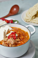 돼지고기 김치찌개가 라면사리와 함께 테이블 위에 놓여져있는 모습