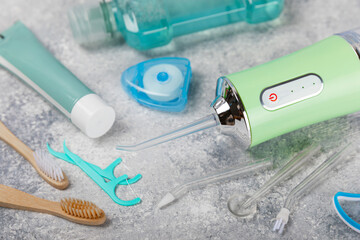 Electronic oral irrigator, toothbrush, paste, dental floss and mouthwash on a blue background....