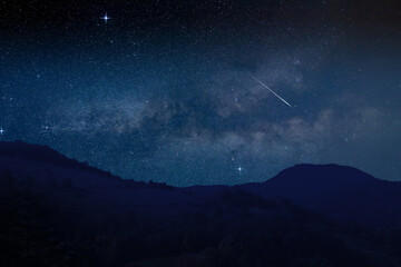 Shooting star, Milky way and landscape silhouettes.