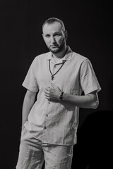 A stylish man with a cross around his neck, black and white picture.