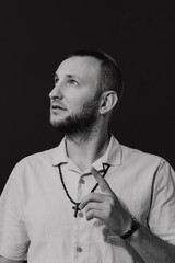 A stylish man with a cross around his neck, black and white picture.