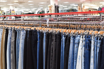 Jeans hanging in a row in a store