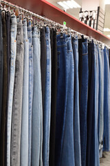 Jeans hanging in a row in a store