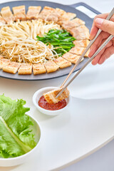 맛있게 구워진 벌집삽겹살 한조각을 쌈장에 찍고 있는 모습