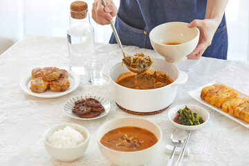 맛있게 끓여진 한우국밥을 개인 그릇에 옮겨 닮고 있는 모습