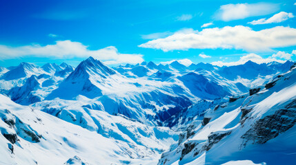 Landscape of a snowy mountain range at bright sunny day with a clear blue sky
