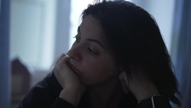 Melancholic woman with pensive expression thinking in deep thoughts at home. Contemplative person pondering life alone in solitude