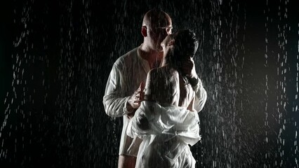 tender kiss and sensual embrace of lovers in rain, middle-aged man and woman kissing and hugging