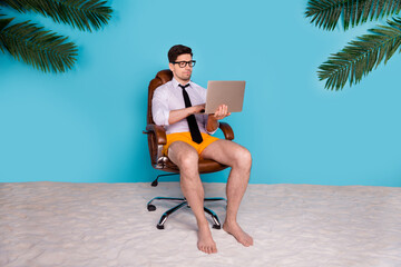 Photo of employee sitting chair using netbook for distance work on summer weekends isolated blue color background