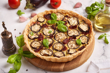 Quiche open tart pie with eggplant, sundried tomatoes and chicken meat. Savory taste. 