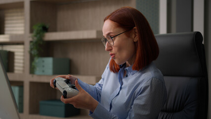 Funny female office worker addicted video game business woman playing console controller play online while nobody see girl businesswoman scared get caught hide joystick pretend working with computer